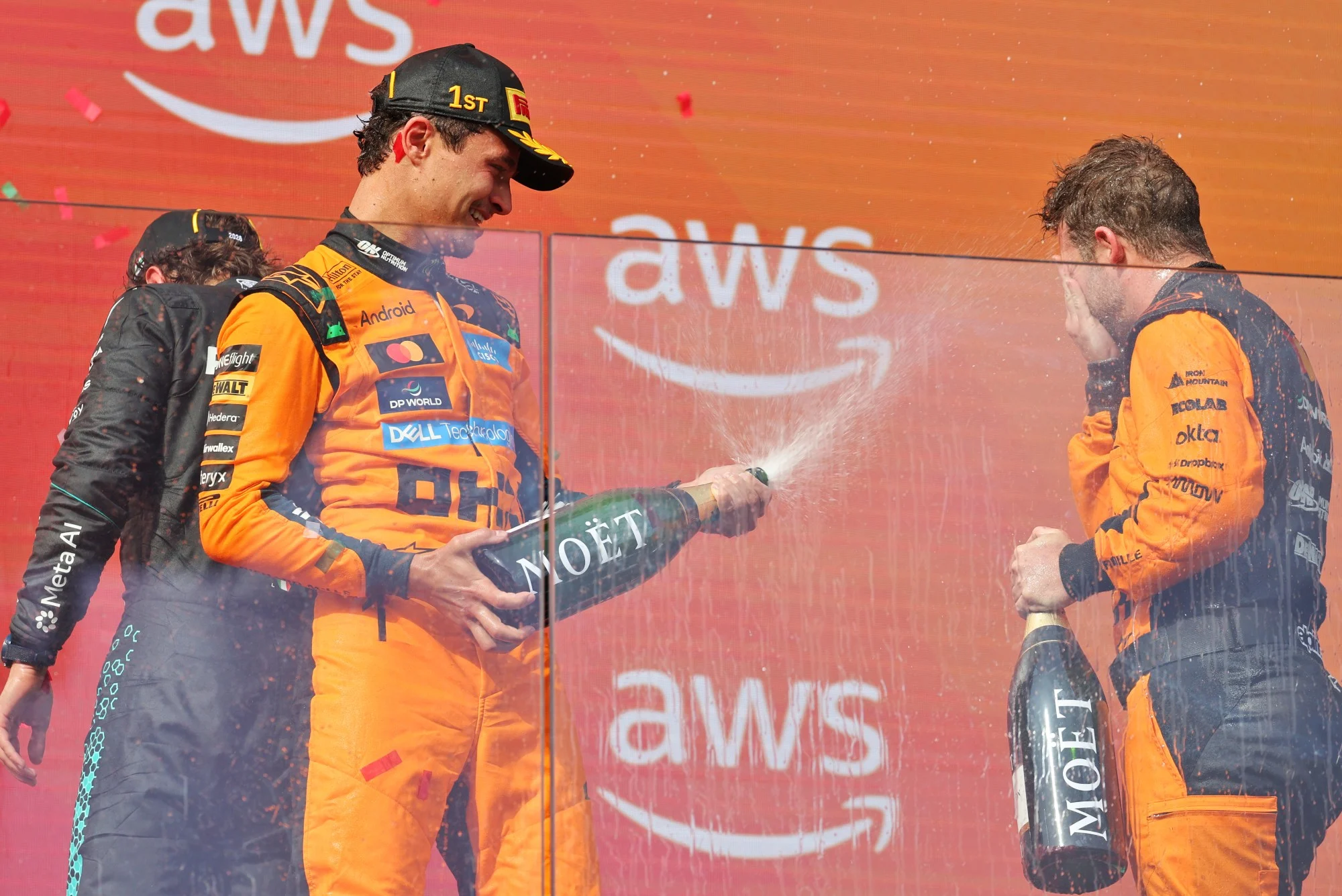 F1: Norris não esperava vitória da McLaren tão cedo em 2026 (L to R): Race winner Lando Norris (GBR) McLaren F1 Team celebrates on the podium with Kyle Moreira (GBR) McLaren F1 Team No. 1 Mechanic.