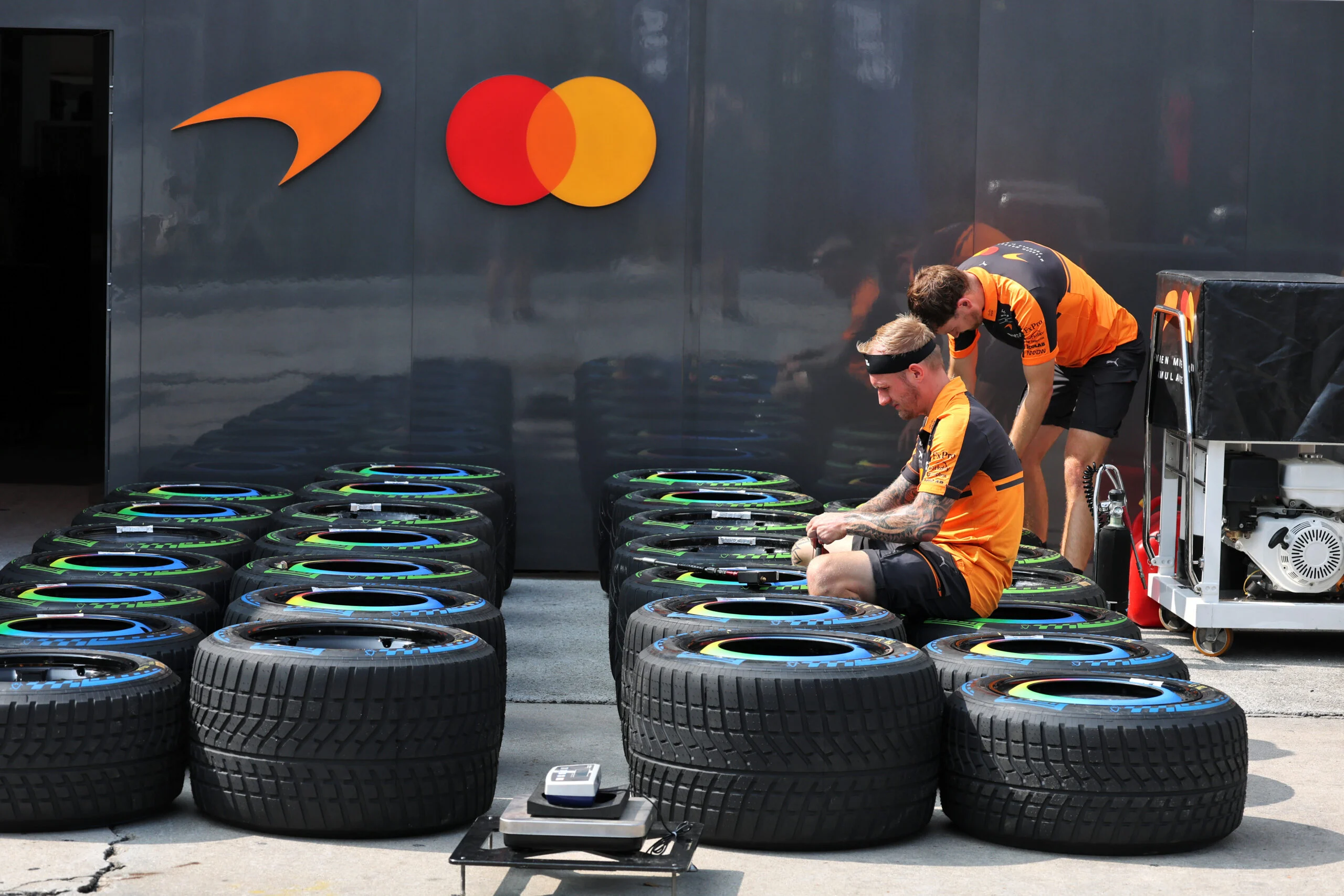 F1 hoje: FIA fecha brecha e McLaren leva novidades a Austin Paddock atmosphere - McLaren F1 Team mechanics with wet Pirelli tyres.